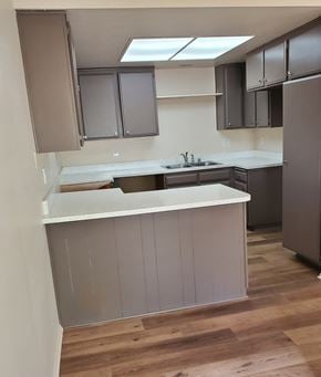 Irvine apartment for rent - an empty kitchen with white counter tops and dark cabinets
