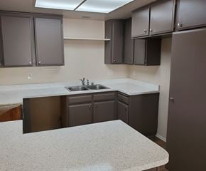 Irvine apartment for rent - an empty kitchen with white counter tops and dark cabinets