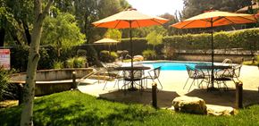 Los Gatos apartment for rent - a backyard with tables and umbrellas next to a swimming pool