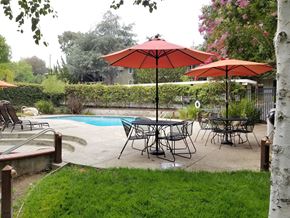Los Gatos apartment for rent - a patio with tables and umbrellas next to a swimming pool