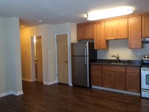 San Francisco apartment for rent - an empty kitchen with wooden cabinets and a refrigerator
