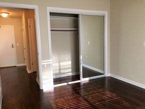 San Francisco apartment for rent - an empty living room with a hard wood floor and sliding glass doors