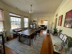 Seattle apartment for rent - an open living room and dining room with a long wooden table and chairs
