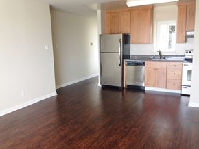 San Francisco apartment for rent - an empty kitchen with wooden floors and a stainless steel refrigerator