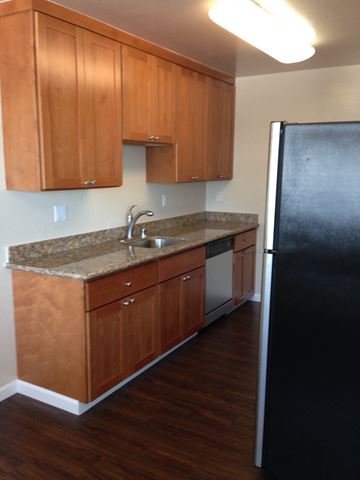 San Francisco apartment for rent - a kitchen with wooden cabinets and a black refrigerator