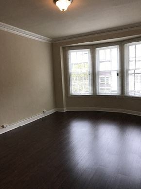 San Francisco apartment for rent - an empty living room with a wood floor and three windows