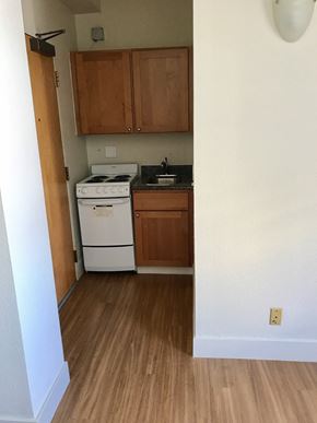 San Francisco apartment for rent - an empty kitchen with wooden flooring and a white stove and refrigerator