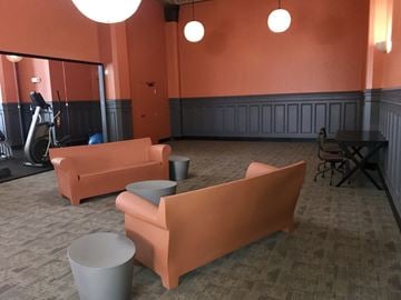San Francisco apartment for rent - a living room with orange couches and a table and chairs