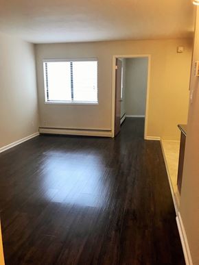 San Francisco apartment for rent - an empty living room with wooden floors and a window