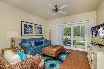 Bradenton apartment for rent - a living room with a blue couch and a tv