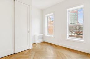 Brooklyn apartment for rent - a living room with white walls and wood floors and two windows