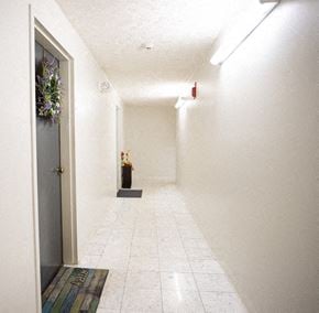 Meriden apartment for rent - a long white hallway with a door and a vase of flowers