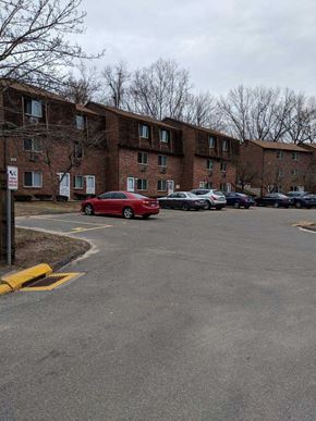 Meriden apartment for rent - a red car parked in a parking lot in front of a building