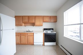 Meriden apartment for rent - an empty kitchen with wooden cabinets and white appliances