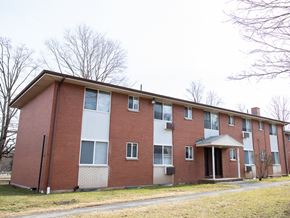 Meriden apartment for rent - a red brick apartment building with trees in the background