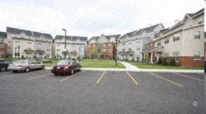 Hartford apartment for rent - a parking lot with cars in front of some buildings