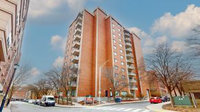 Malden apartment for rent - A tall red brick building with a parking lot in front.