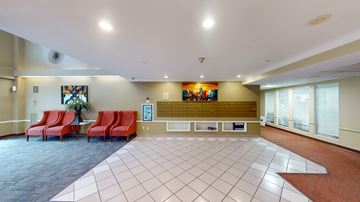 Malden apartment for rent - A spacious waiting area with red chairs and a large painting on the wall.