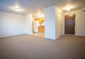 Wallingford apartment for rent - an empty living room with a kitchen in the background