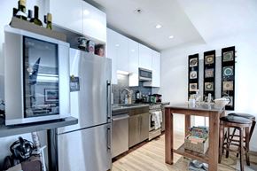 New York apartment for rent - a kitchen with stainless steel appliances and a wooden table