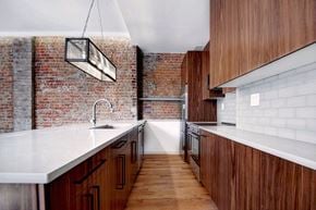 New York apartment for rent - a kitchen with wooden cabinets and a brick wall