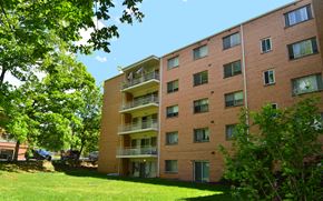 Hyattsville apartment for rent - a large brick apartment building with a green lawn