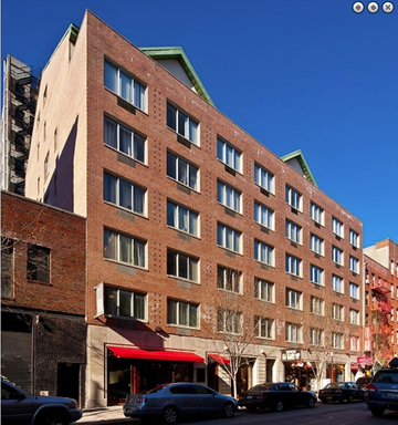 New York apartment for rent - a tall brick building with cars parked in front of it