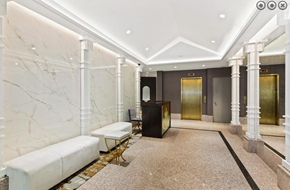 New York apartment for rent - a lobby with white marble pillars and a reception desk