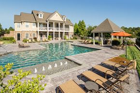 Columbus apartment for rent - a large swimming pool with patio furniture in front of a house