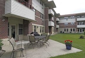 Waunakee apartment for rent - a patio with a table and chairs in front of a building