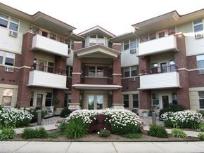 Waunakee apartment for rent - the front of a brick apartment building with white flowers