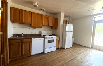 Madison apartment for rent - an empty kitchen with white appliances and wooden cabinets