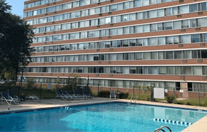 Madison apartment for rent - A swimming pool in front of a tall building.