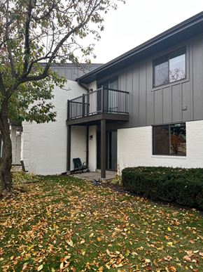 Madison apartment for rent - the exterior of a house with a balcony and a yard with fallen leaves