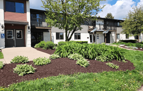 Madison apartment for rent - a garden in front of a building with a sidewalk