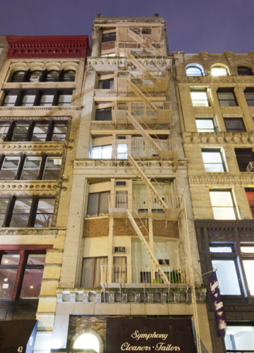 New York apartment for rent - a group of tall buildings with fire escapes