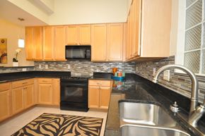 Durham apartment for rent - a kitchen with black counter tops and wooden cabinets