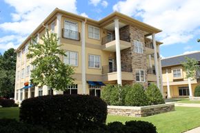 Durham apartment for rent - an exterior view of a building with a lawn and bushes