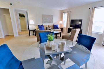 Baltimore apartment for rent - a living room with blue chairs and a glass table