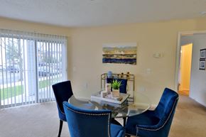 Baltimore apartment for rent - a dining room with a glass table and blue chairs