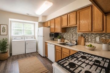 Windsor Mill townhouse for rent - A kitchen with a black stove top oven and wooden cabinets.