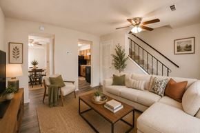 Windsor Mill townhouse for rent - A living room with a white couch, a coffee table, and a staircase.
