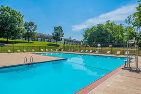 Windsor Mill townhouse for rent - a swimming pool with trees and a building in the background