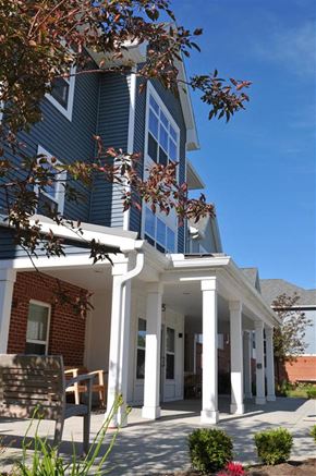 Cleveland apartment for rent - A blue building with a white porch and a bench.