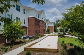 Brooksville apartment for rent - Outdoor shuffleboard court with shaded pavilion seating, landscaped surroundings, and a relaxing space for recreation and socializing.