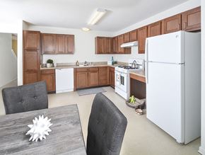 Columbus apartment for rent - A modern kitchen with a white refrigerator and wooden cabinets.