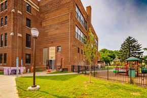 Schenectady apartment for rent - a large brick building with a playground in front of it