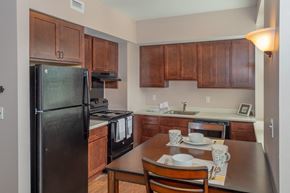 Schenectady apartment for rent - a kitchen with black appliances and a wooden table and chairs