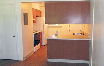 Caldwell apartment for rent - an empty kitchen with wood flooring and white cabinets