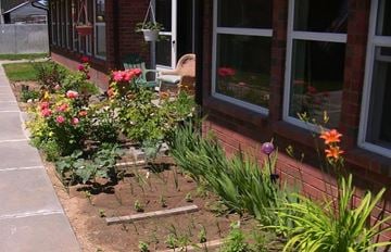 Kimberly apartment for rent - a flower garden in front of a brick building